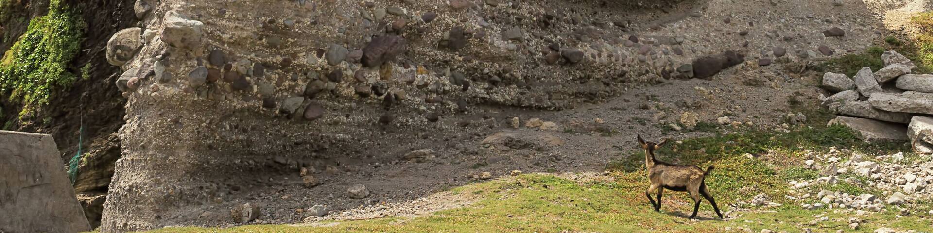 A rocky cliff with a person climbing.