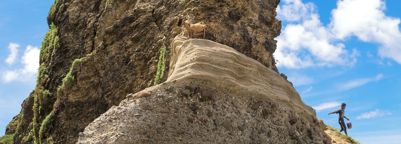 A goat herder and his goats on the Alapad Rock Formation in Sabtang Island, Batanes, one of the northernmost inhabited isles in the Philippines.