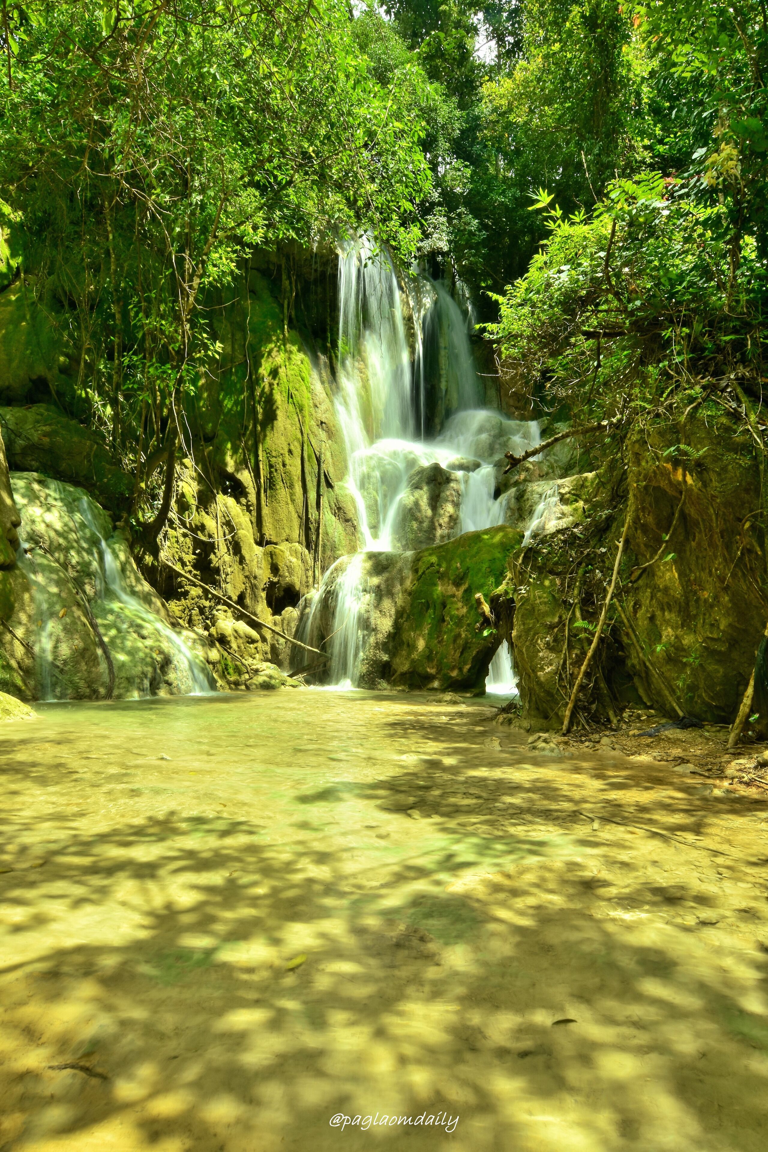 A waterfall cascading over rocks in a forested area.