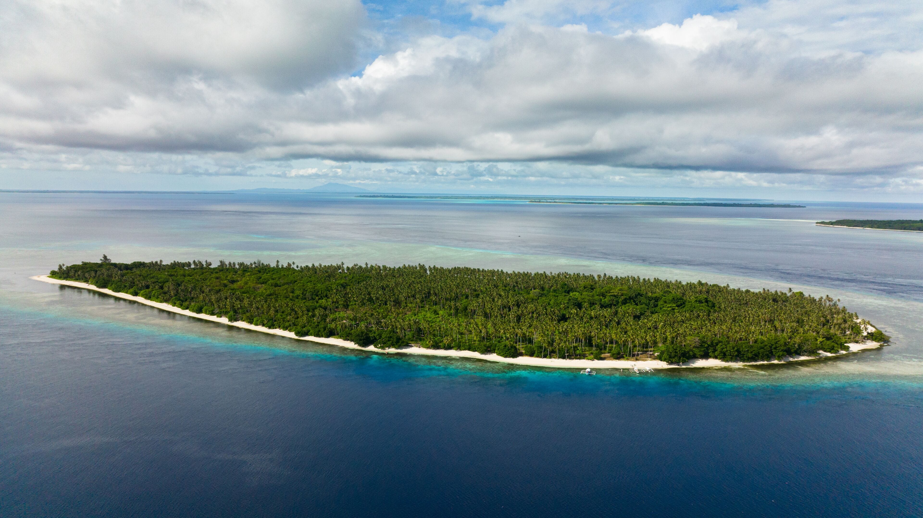 An aerial view of a tropical island surrounded by turquoise waters.