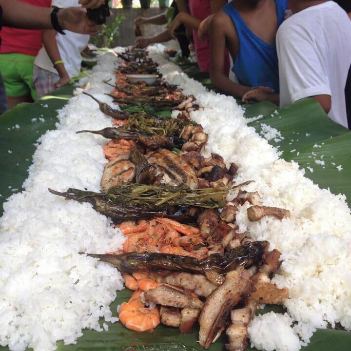 A long table with white rice and various seafood dishes.