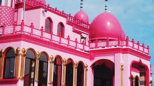In the Philippines, specifically in Datu Saudi Ampatuan, Maguindanao, a noteworthy mosque that stands for peace has become quite a spectacular attraction. Can you guess what color? Yes. This is the Pink Mosque, or formally called, Masjid Dimaukom.
Masjid Dimaukom is clad in vibrant shades of pink – from the carnation-colored walls adorned by golden arches of its glass windows, to the lively cerise domes accented with silver spires, as well as silver star and crescents that face east. But that’s not it. The spacious interiors dominated by pink hues from its walls to the high ceilings, the shiny carmine of the tiled flooring, the bold golden pillars – the inside is equally captivating. This edifice is certainly an eye candy from inside out.
Beyond the structure’s aesthetic appeal, the Pink Mosque was built, primarily, as a sacred place of prayer, and also a symbol of peace. A unique structure that exemplifies harmony among Filipinos, regardless of religion, ethnicity, culture, and social class. The mosque is a brainchild of a man who believes in his love for the country, its people, and above all, the love for Allah.
