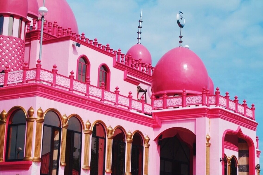 In the Philippines, specifically in Datu Saudi Ampatuan, Maguindanao, a noteworthy mosque that stands for peace has become quite a spectacular attraction. Can you guess what color? Yes. This is the Pink Mosque, or formally called, Masjid Dimaukom.
Masjid Dimaukom is clad in vibrant shades of pink – from the carnation-colored walls adorned by golden arches of its glass windows, to the lively cerise domes accented with silver spires, as well as silver star and crescents that face east. But that’s not it. The spacious interiors dominated by pink hues from its walls to the high ceilings, the shiny carmine of the tiled flooring, the bold golden pillars – the inside is equally captivating. This edifice is certainly an eye candy from inside out.
Beyond the structure’s aesthetic appeal, the Pink Mosque was built, primarily, as a sacred place of prayer, and also a symbol of peace. A unique structure that exemplifies harmony among Filipinos, regardless of religion, ethnicity, culture, and social class. The mosque is a brainchild of a man who believes in his love for the country, its people, and above all, the love for Allah.