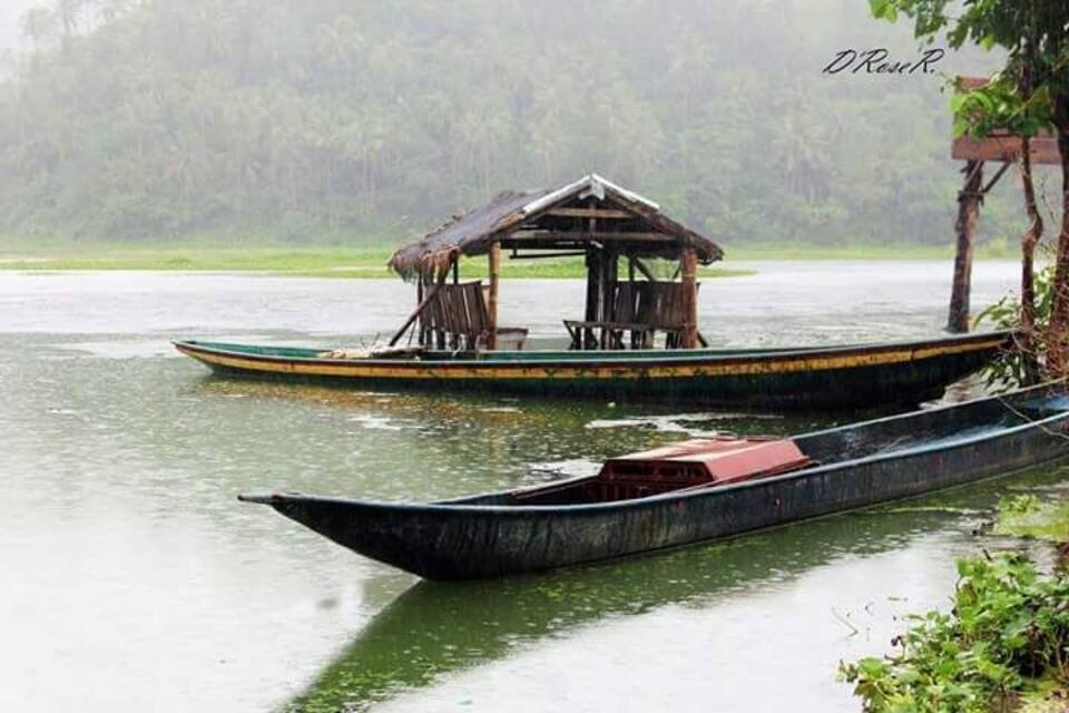 A river with two boats, one with a shelter and the other without.