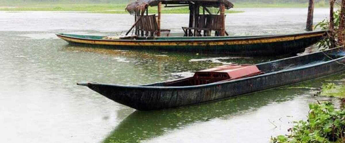 A river with two boats, one with a shelter and the other without.