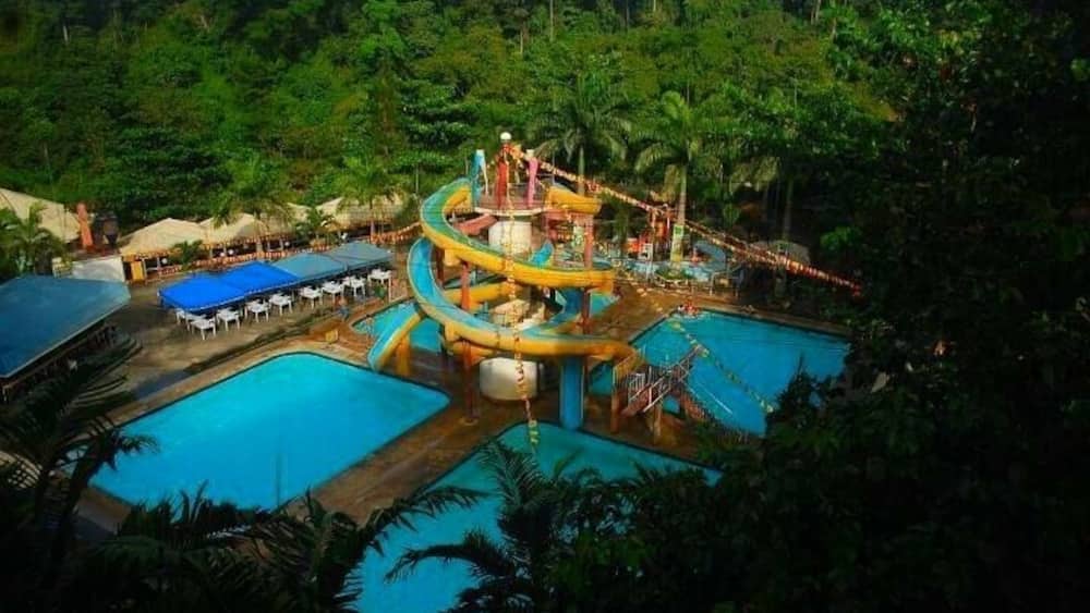 A water park with multiple pools and a large water slide.