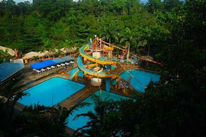 A water park with multiple pools and a large water slide.