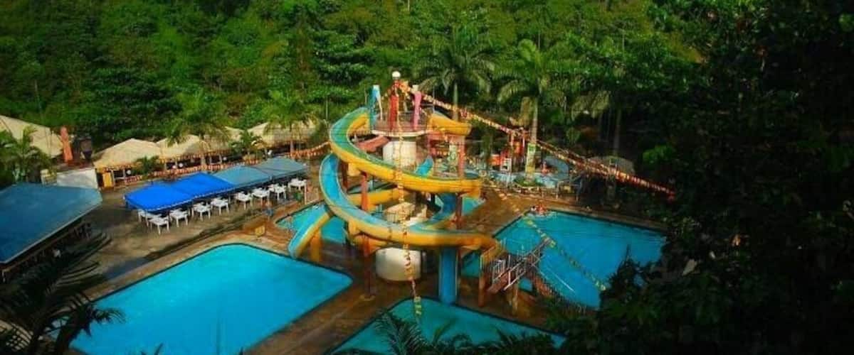 A water park with multiple pools and a large water slide.