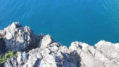 A rocky coastline with clear blue sea.