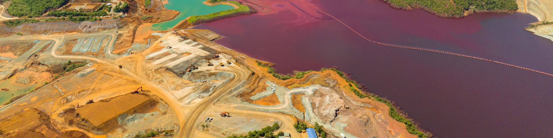 Open pit nickel mine and burgundy water lake. Polluted air and water. Mindanao, Philippines.
