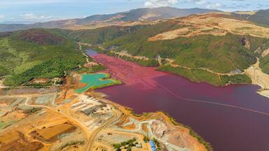 Open pit nickel mine and burgundy water lake. Polluted air and water. Mindanao, Philippines.