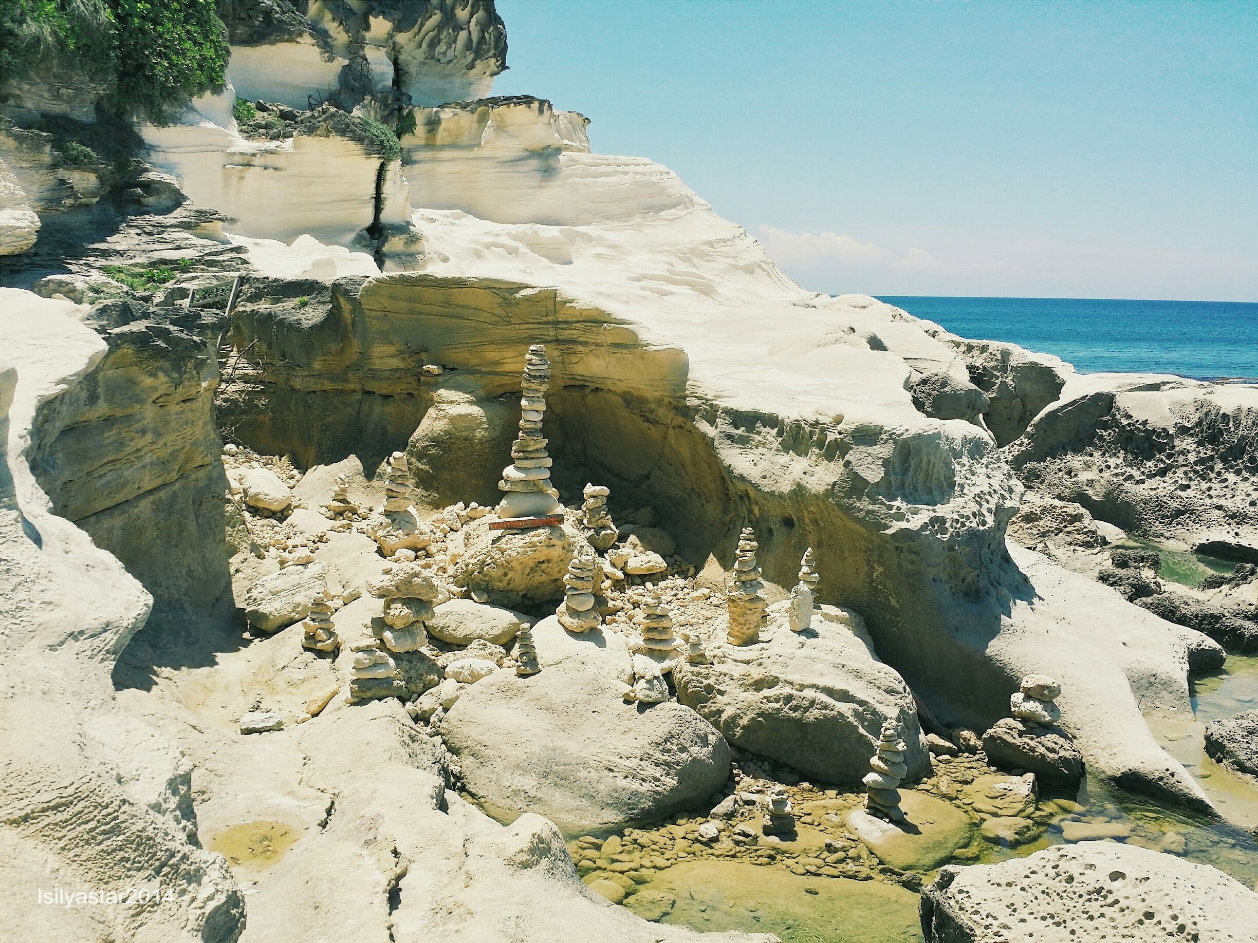 A coastal landscape with stacked rocks and cliffs.