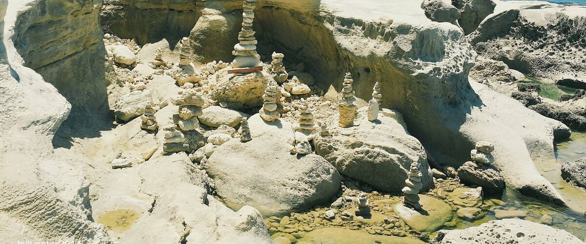 A coastal landscape with stacked rocks and cliffs.