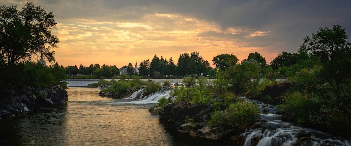 The Heart of Idaho Falls over the Snake River Waterfront at Sunrise in Bonneville County, Idaho, USA: The serene waterfalls flowing through the center of town