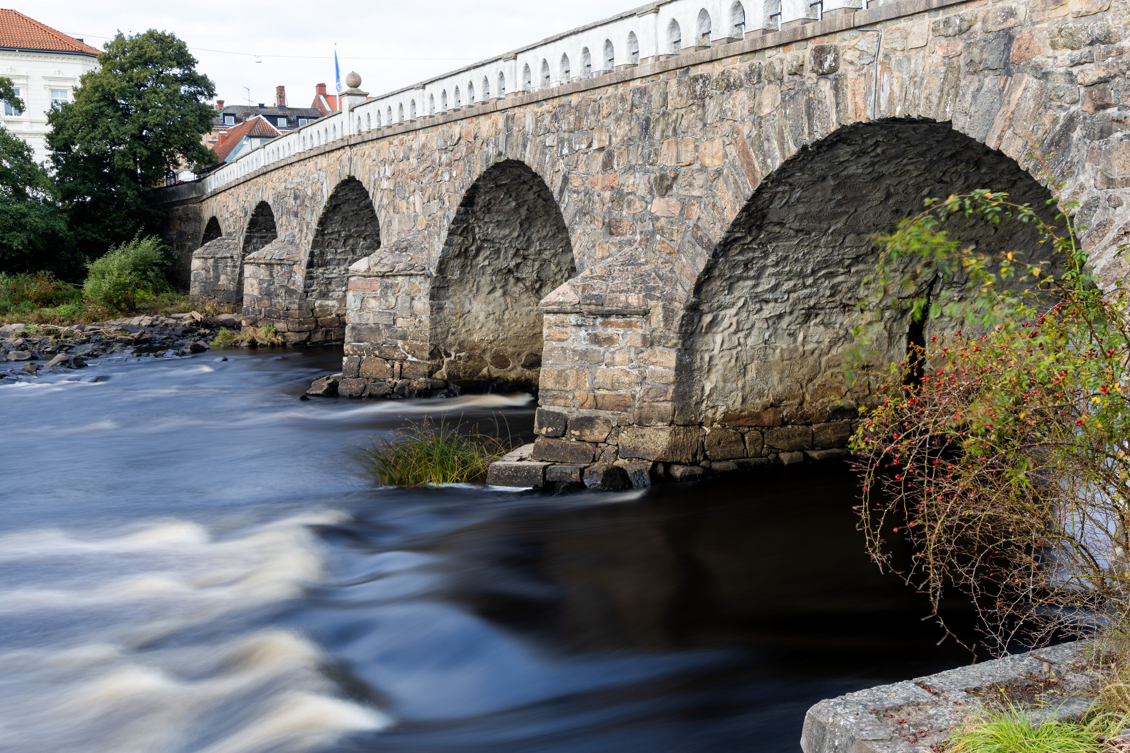 Stone arch bridge over river in long exposure in Falkenberg, Sweden