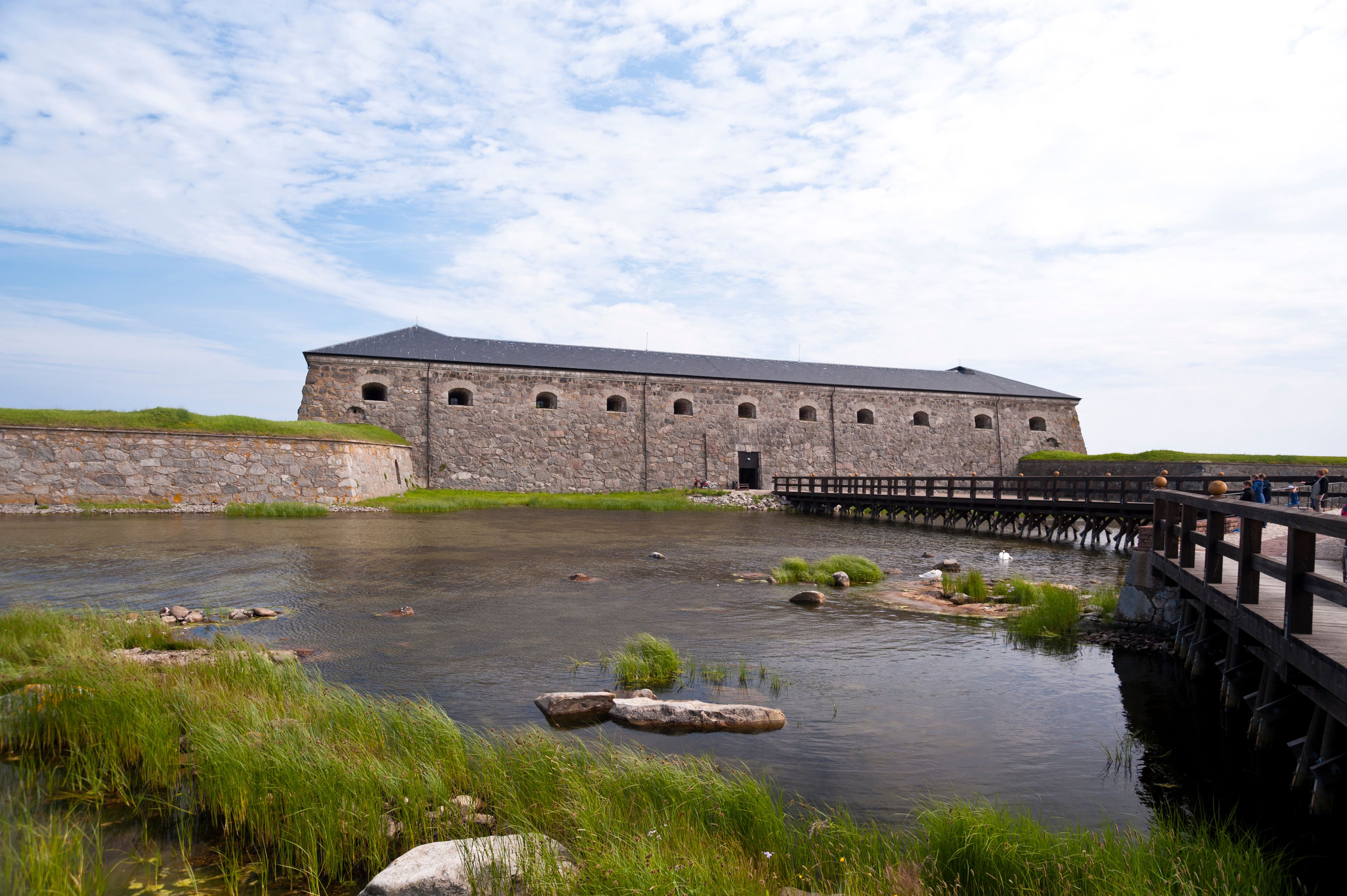 A stone building with a bridge over a river.