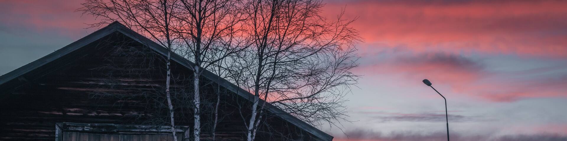 Sweden Jämtland (Lapland). The church of Storsjö, a cozy town next to Ljungdalen during blue hour. An old barn in the foreground. Snow is melting.