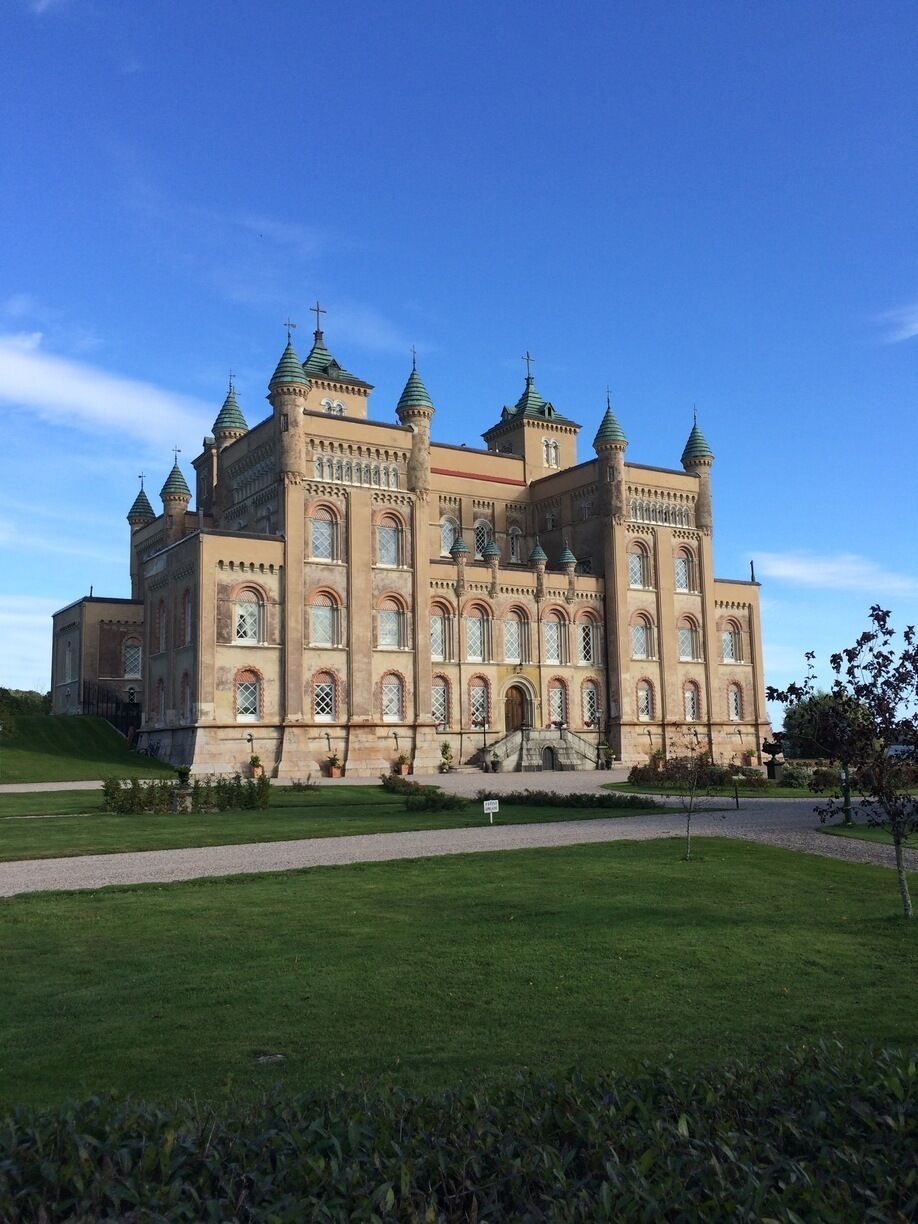 A large, ornate building with multiple towers and arched windows.