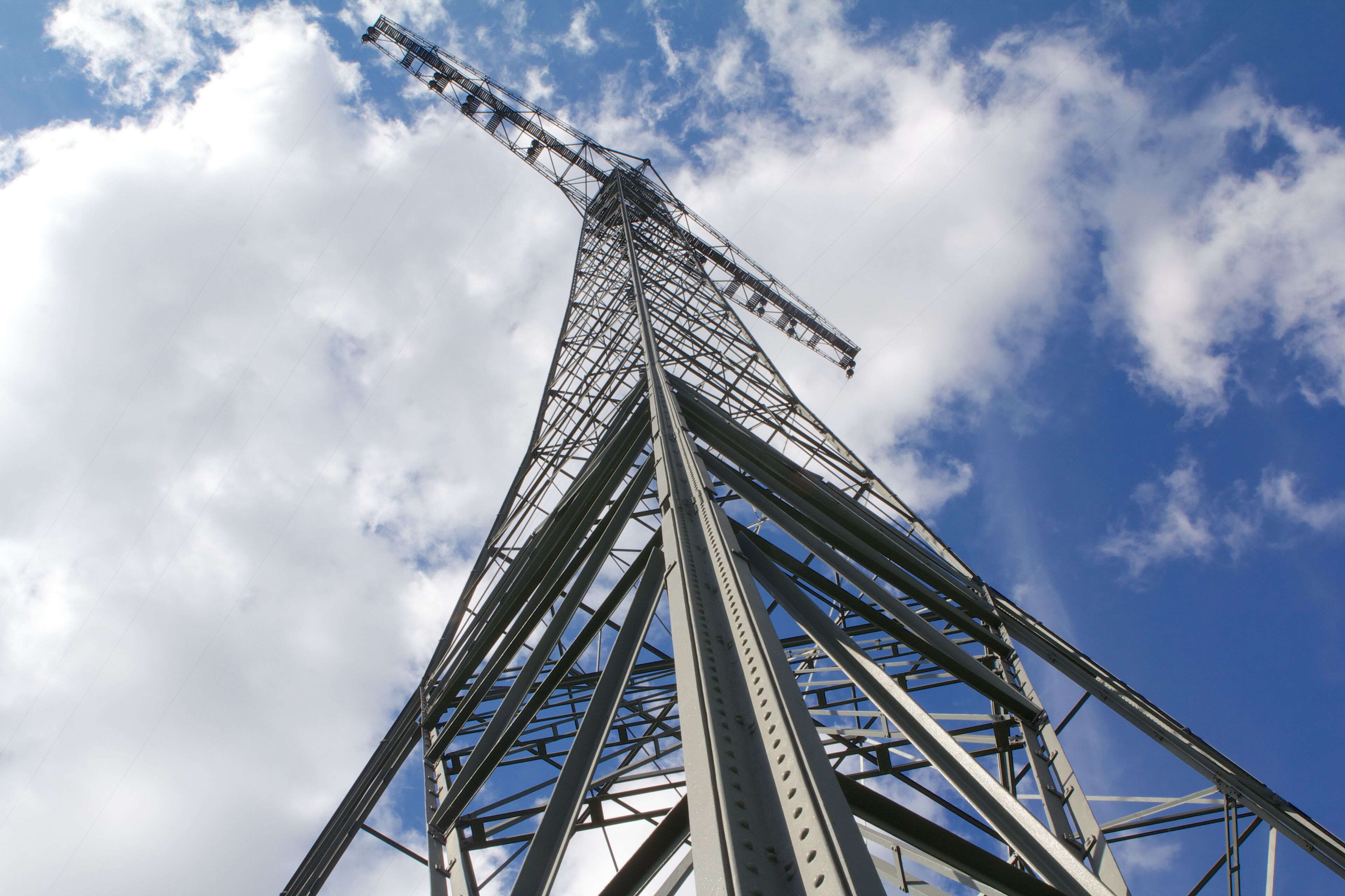A tall metal tower against a blue sky with clouds.