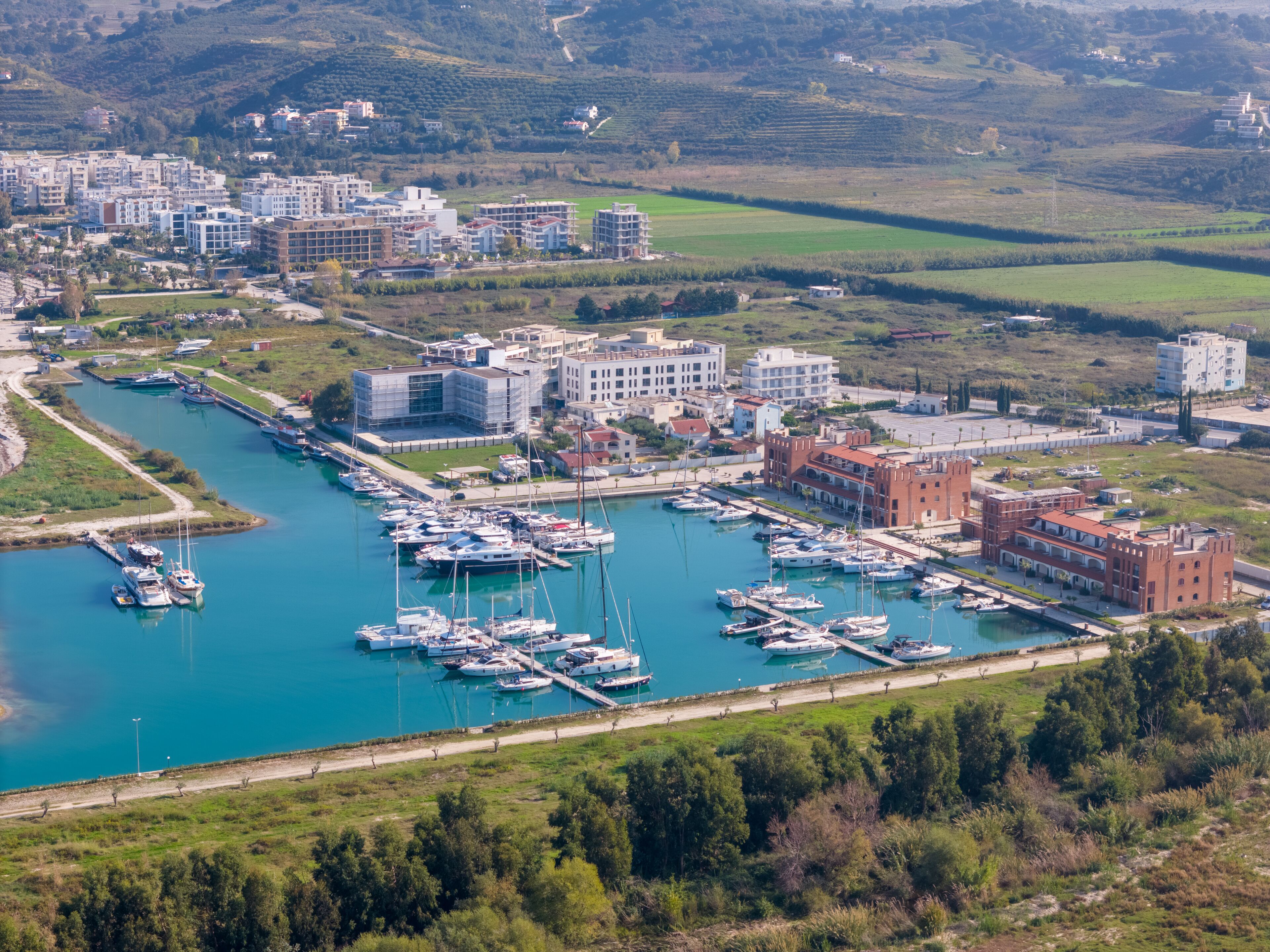 Aerial drone view of the coastal town and marina in Orikum, Albania.