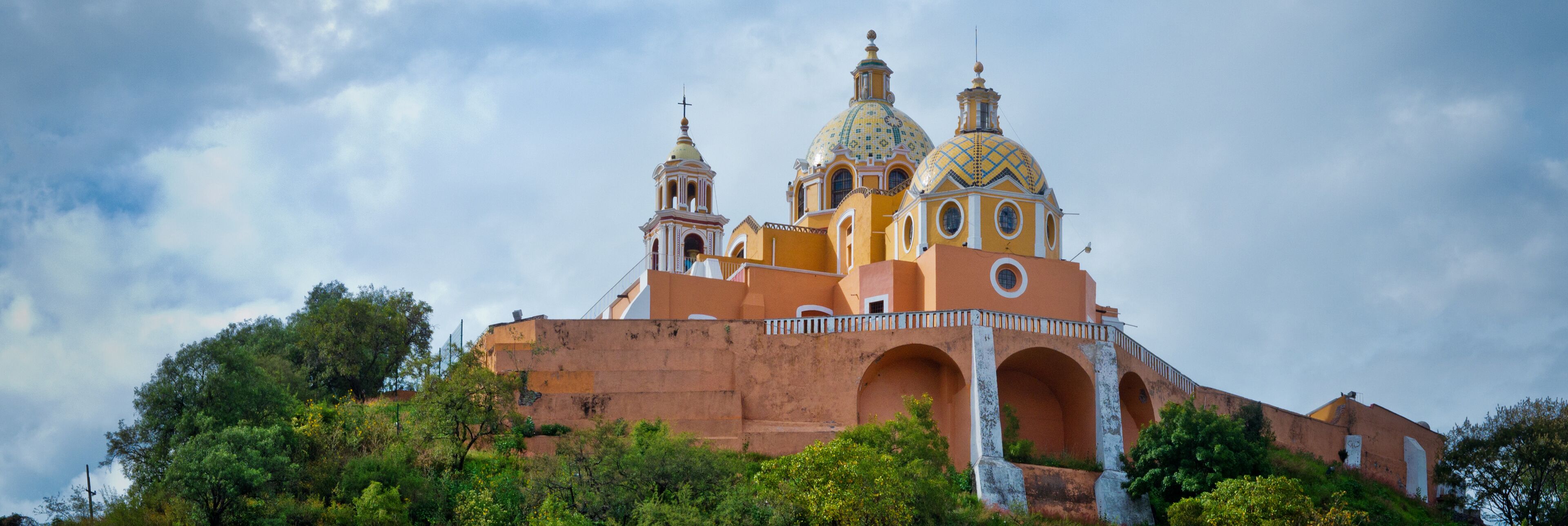 A church with three domes and a bell tower.