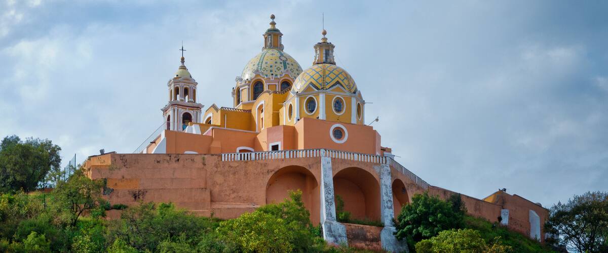 A church with three domes and a bell tower.