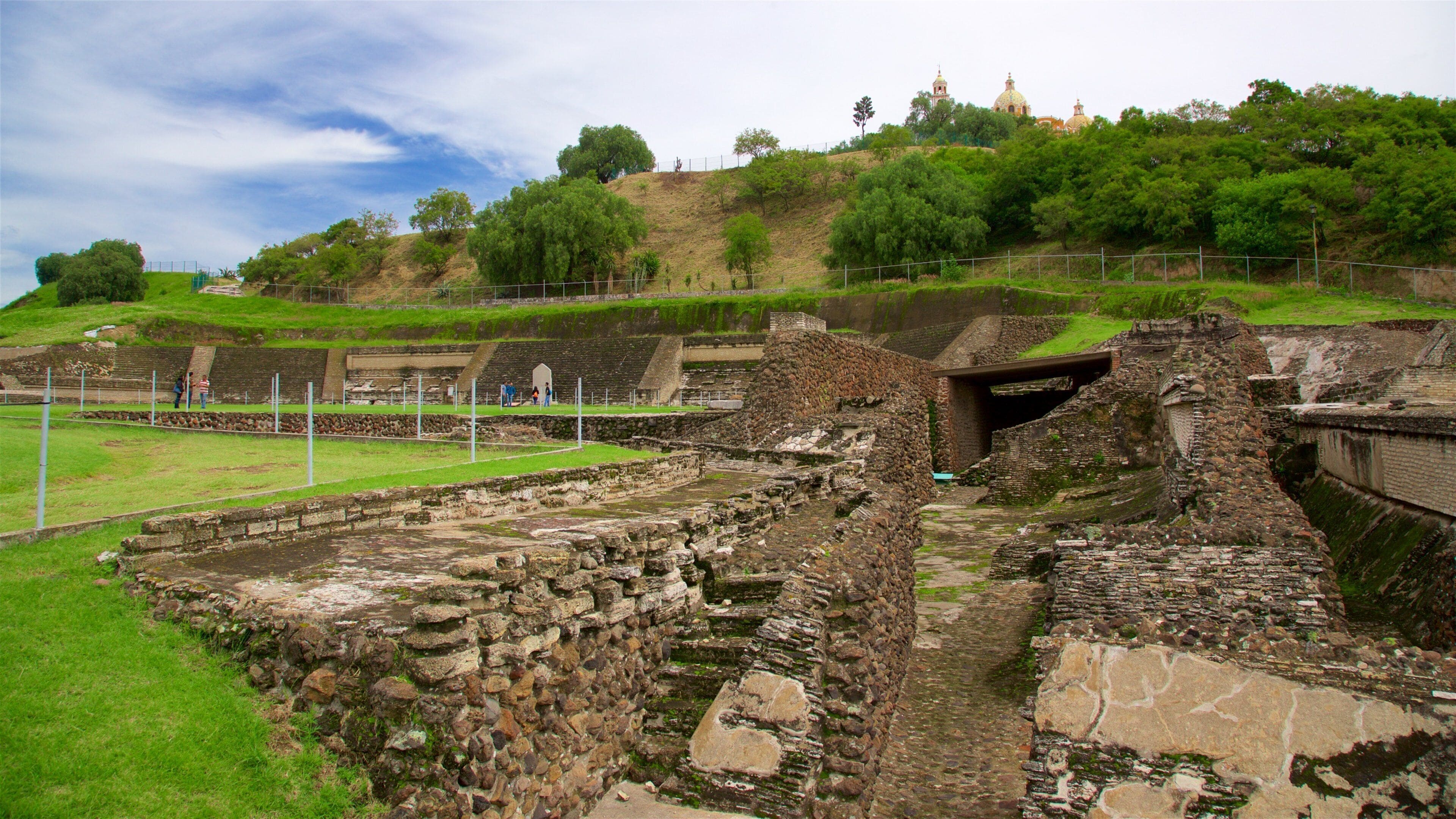 Ancient ruins with stone structures and a grassy area.