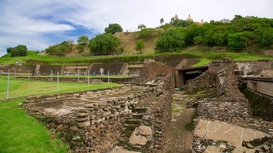 Ancient ruins with stone structures and a grassy area.