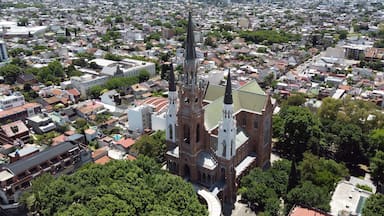 An aerial view of a city with a prominent church featuring a tall spire and a clock tower.