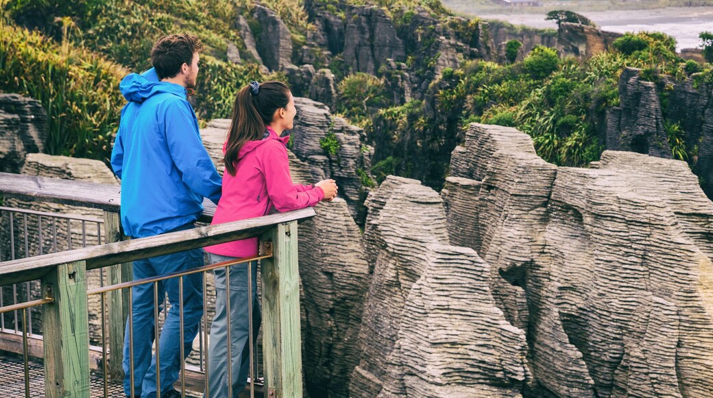 New zealand tourism lifestyle. Punakaiki Pancake Rocks tourists couple travel in Paparoa National Park, West Coast, South Island, New Zealand. Panoramic banner.