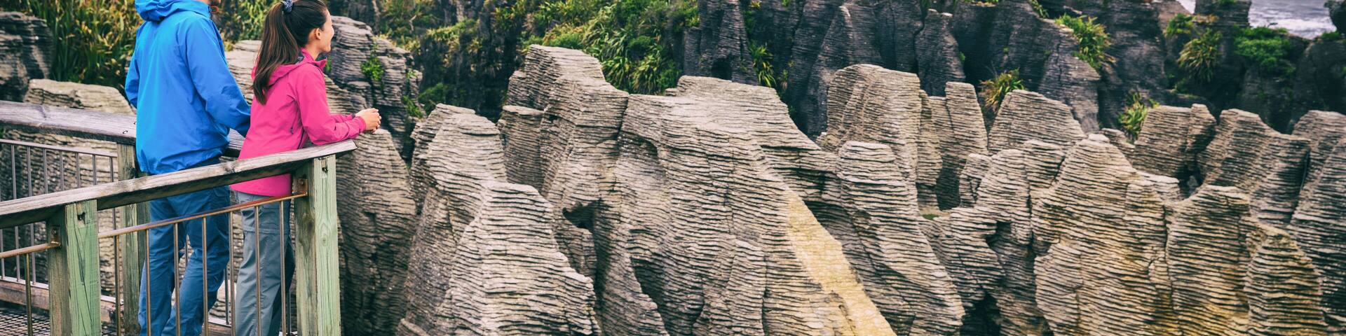 New zealand tourism lifestyle. Punakaiki Pancake Rocks tourists couple travel in Paparoa National Park, West Coast, South Island, New Zealand. Panoramic banner.