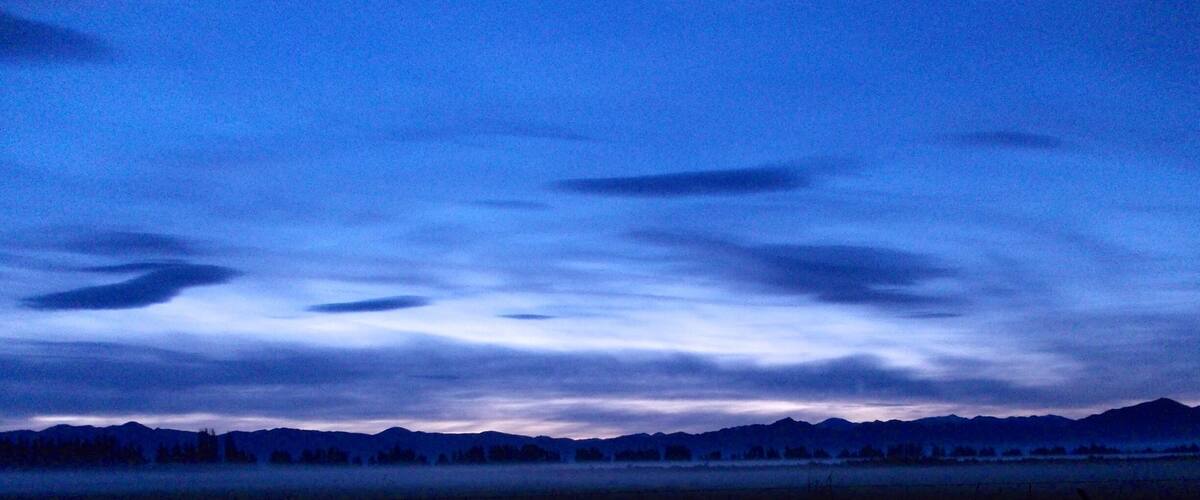 A mountain range at dusk with a clear sky.