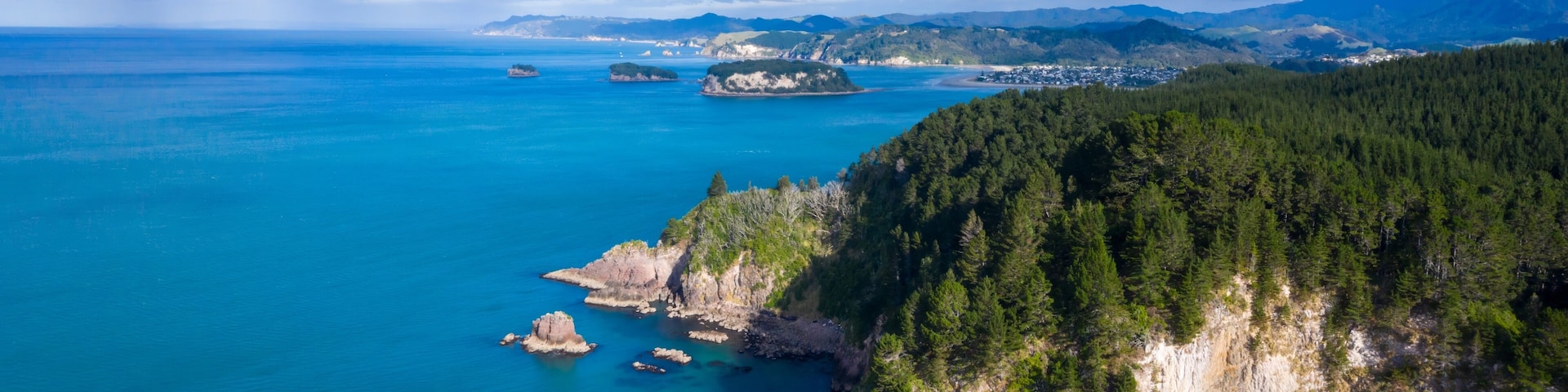 Coastal Coromandel New Zealand scenery. Rocky cliffs meet turquoise water, lush forest. Aerial view. , Whangamata, New Zealand
