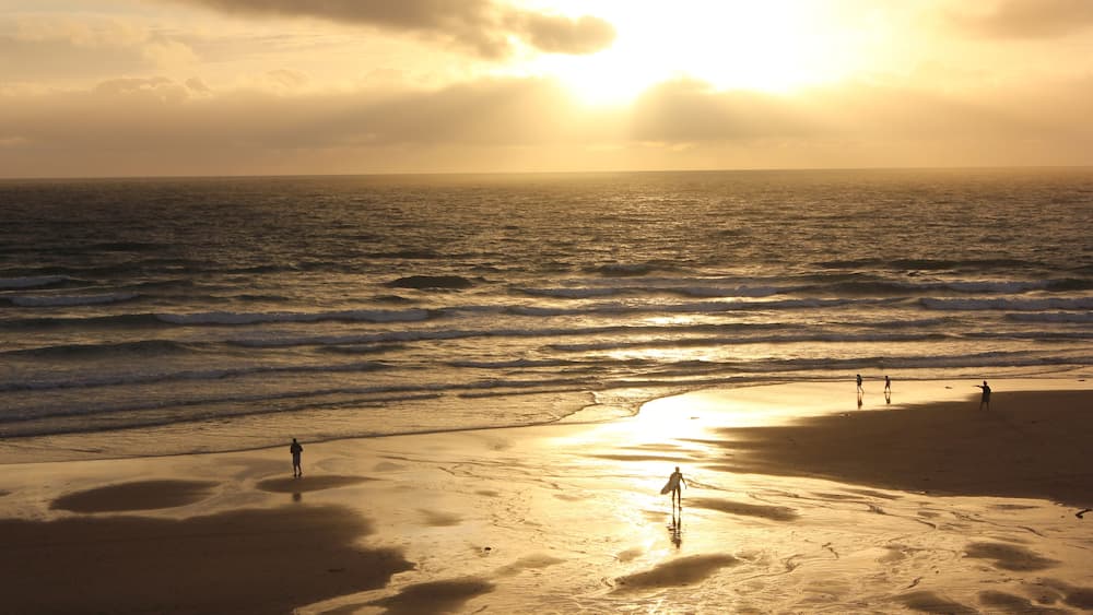 Beautiful sunset in Lacanau Ocean Beach with surfers and walkers, Gironde near Bordeaux, France