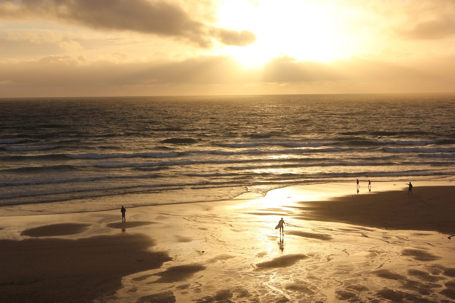 Beautiful sunset in Lacanau Ocean Beach with surfers and walkers, Gironde near Bordeaux, France