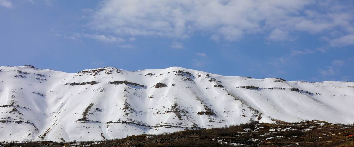 Beautiful view of the Bsharri District mountains covered in snow on a sunny day