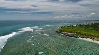 Aerial view of tropical island with coral reef and palm trees, Ha'atafu, Tonga.