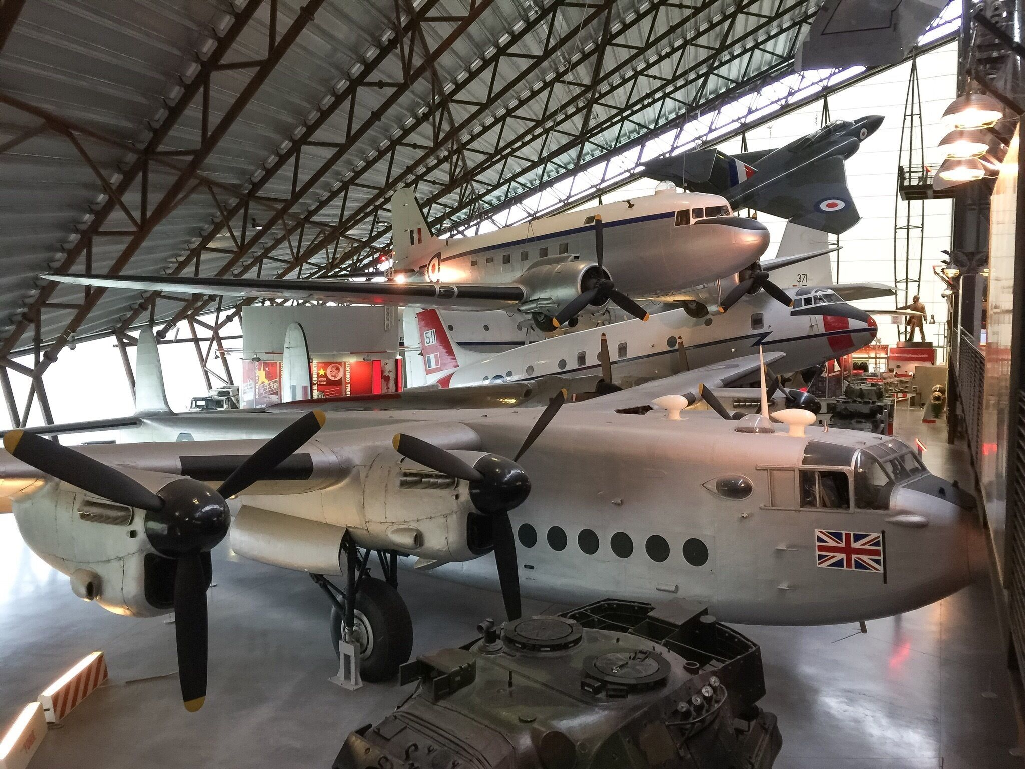 A large aircraft with a Union Jack flag, a propeller, and a British roundel on its tail.