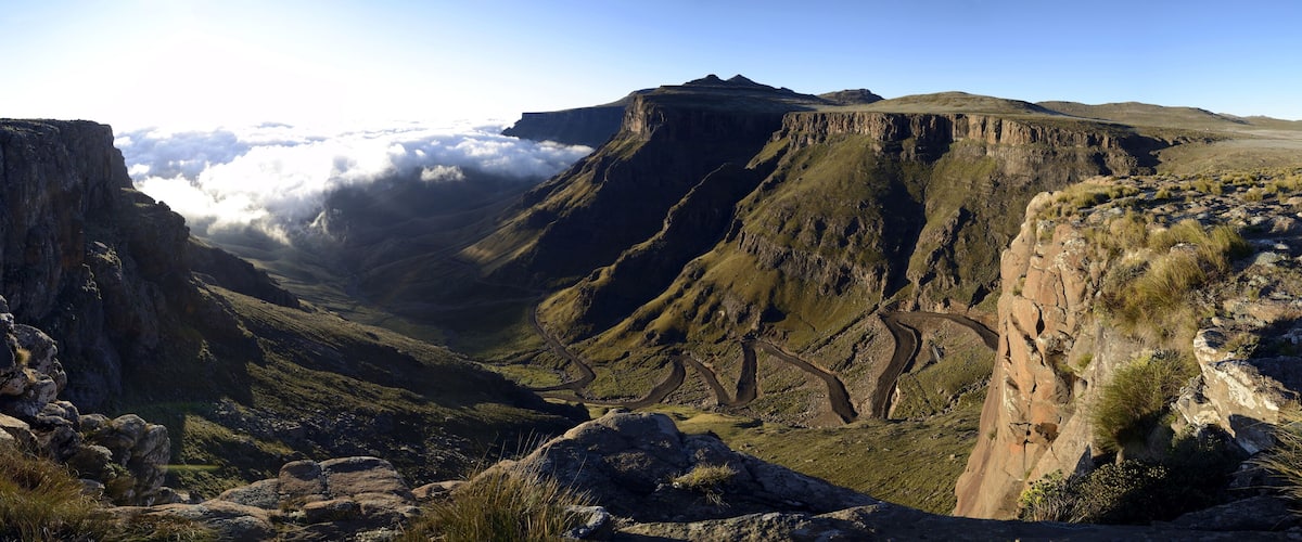 A canyon with steep cliffs and a winding road.