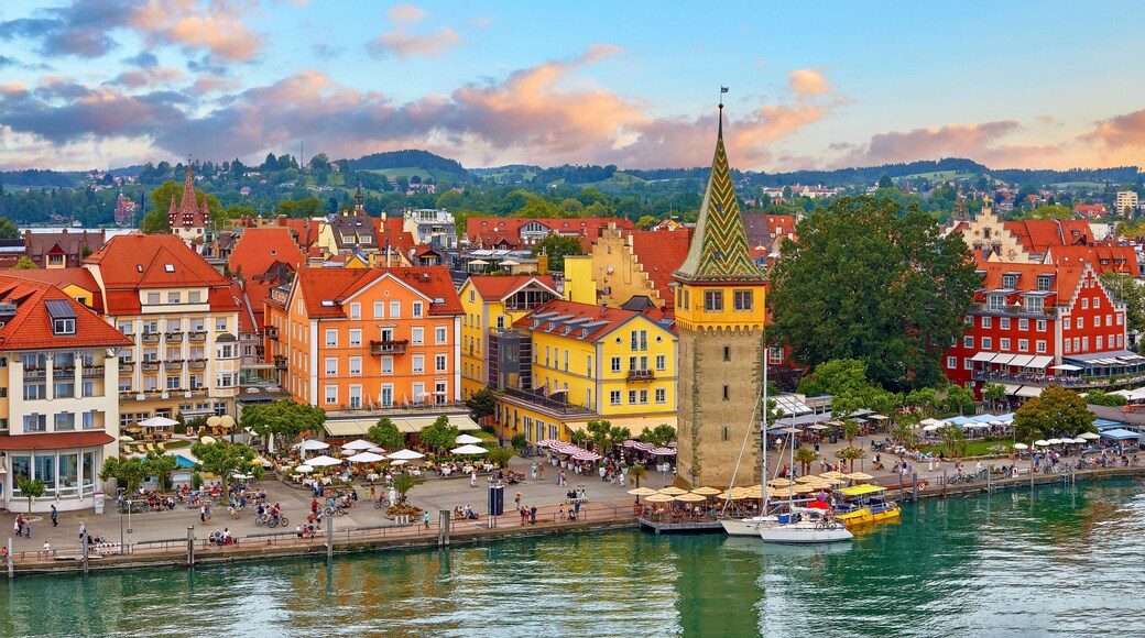 Lindau, Germany. Antique Bavarian town in Bavaria at coastline of Lake Constance (Bodensee). Habour along embankment with traditional houses and tower. Sunset evening landscape.