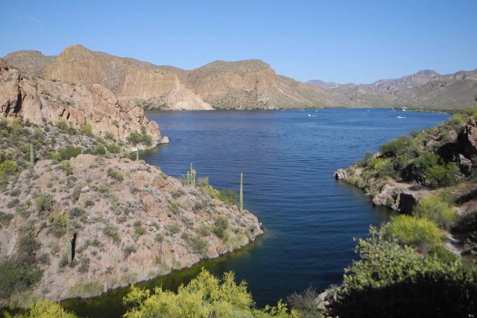 A river winding through a rocky canyon with sparse vegetation and distant mountains.