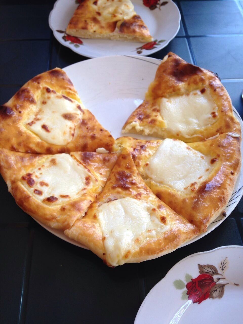 A pizza with cheese on a plate.