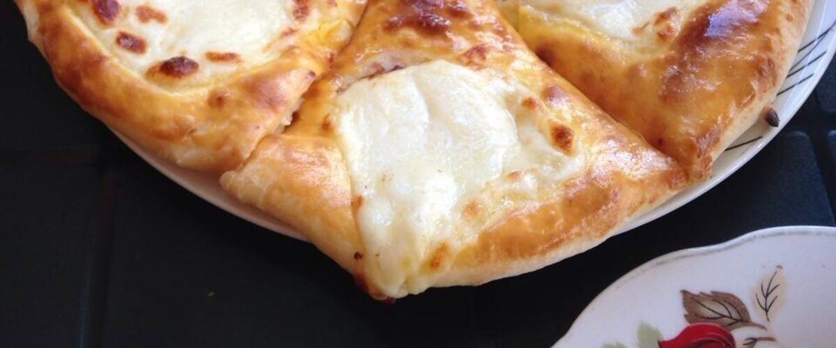 A pizza with cheese on a plate.