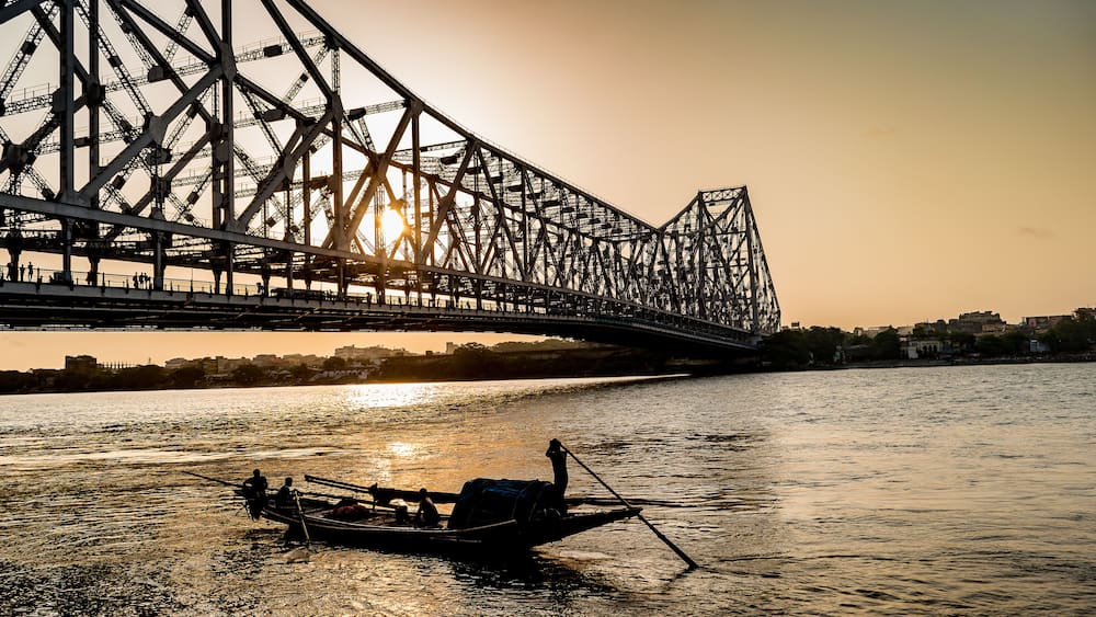 Silhouette of Howrah Bridge at the time of Sunrise. Howrah Bridge is a bridge with a suspended span over the Hooghly River in West Bengal.
