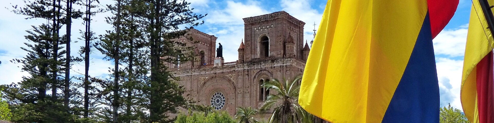 Um edifício histórico com uma grande janela em arco e uma estátua em frente.