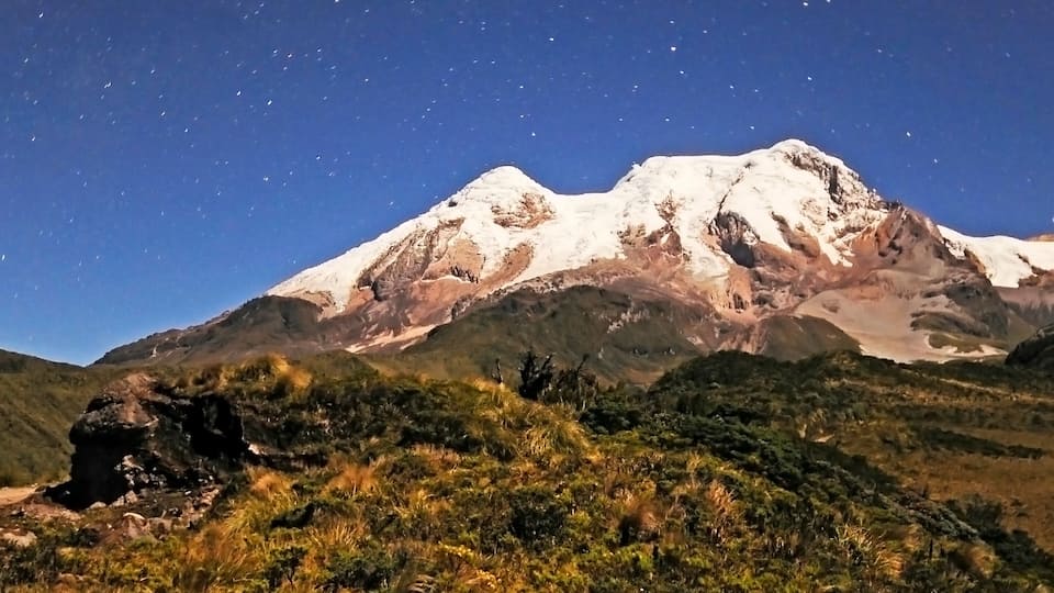A snow-capped mountain with a clear night sky.