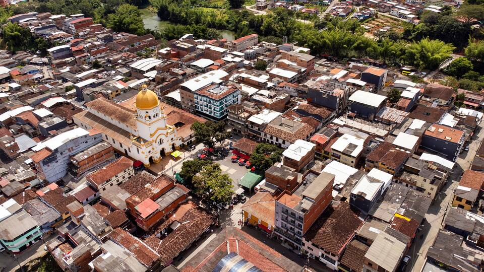 An aerial view of a densely packed urban area with a prominent church featuring a golden dome.