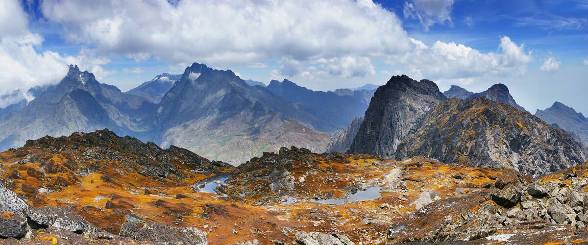 Rugged mountains with orange lichen and a clear sky.