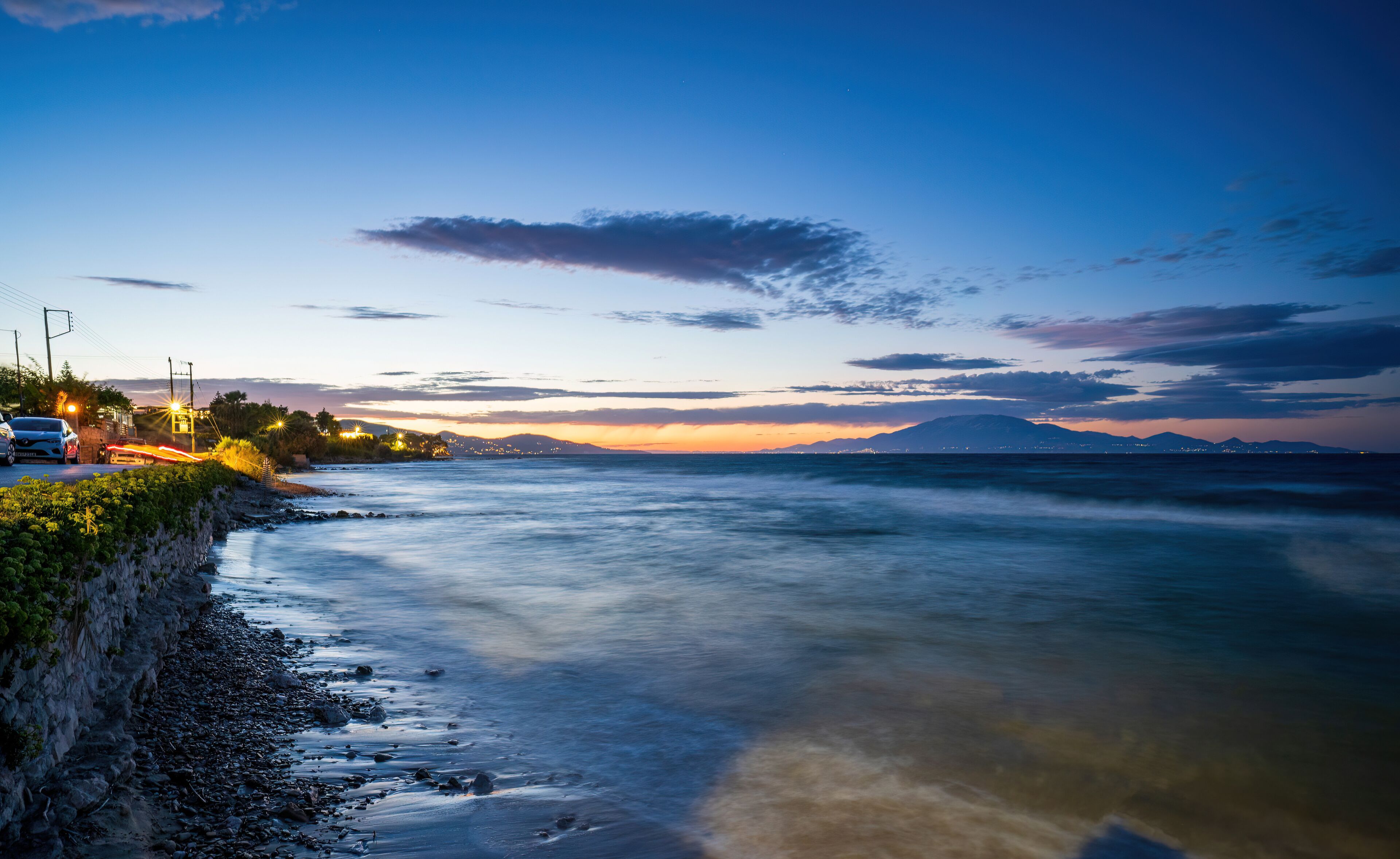 Long exposure shot of a coastal view of Mediterranean Sea during sunset next to car parks near drosia located in Zakynthos, Greece