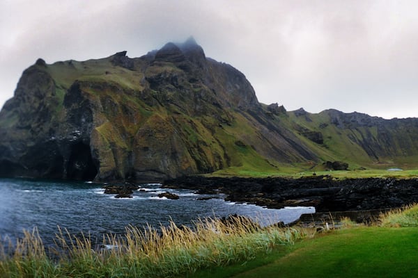 Panoramic green landscape along the coastline, Heimaey island, Westman Islands, Iceland.